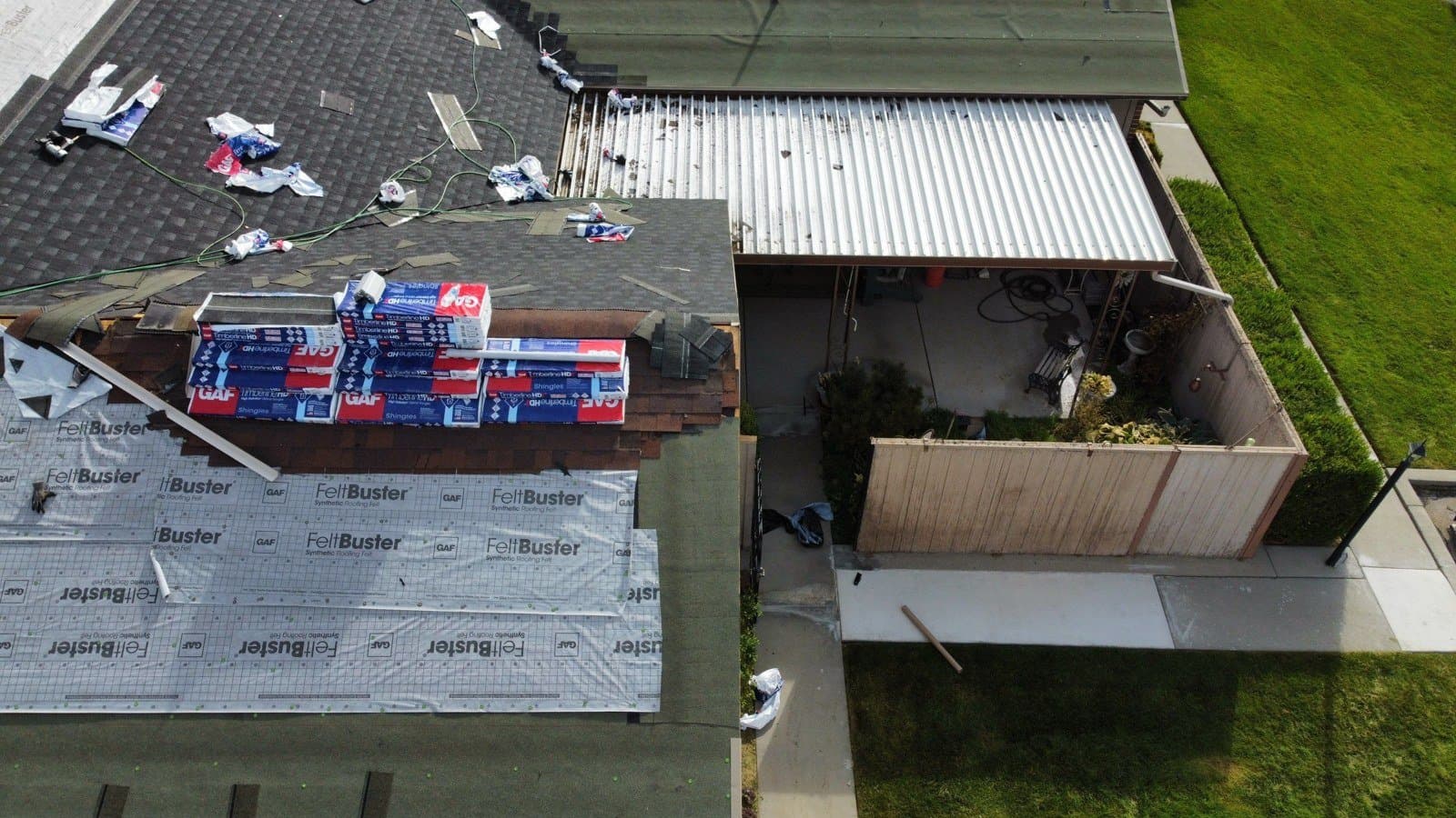 Aerial view looking down on Grandview Farm roofs during installation, with GAF FeltBuster underlayment and Timberline shingle bundles staged, September 2025