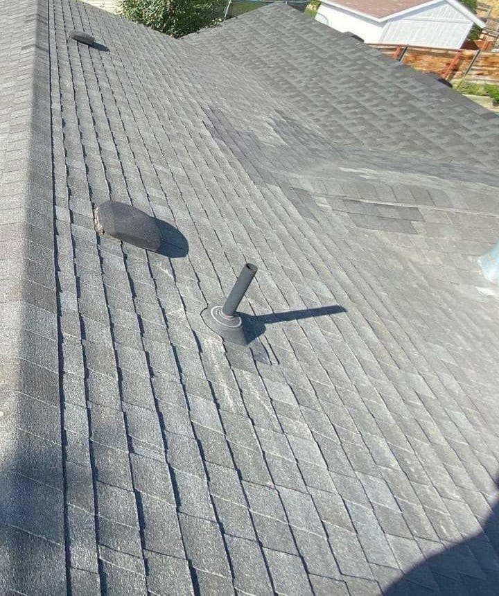 Old gray asphalt shingles, a vent and a pipe flashing on an Orem roof before replacement